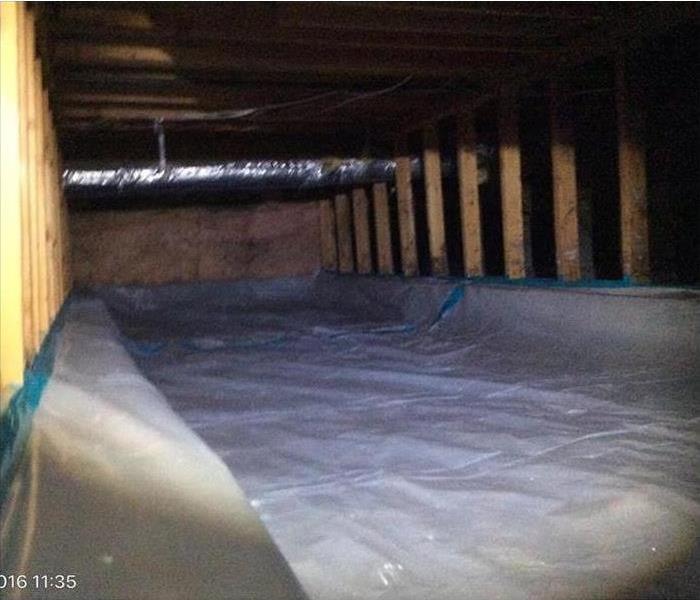 crawlspace cleaned plastic floor covering, support timbers shown